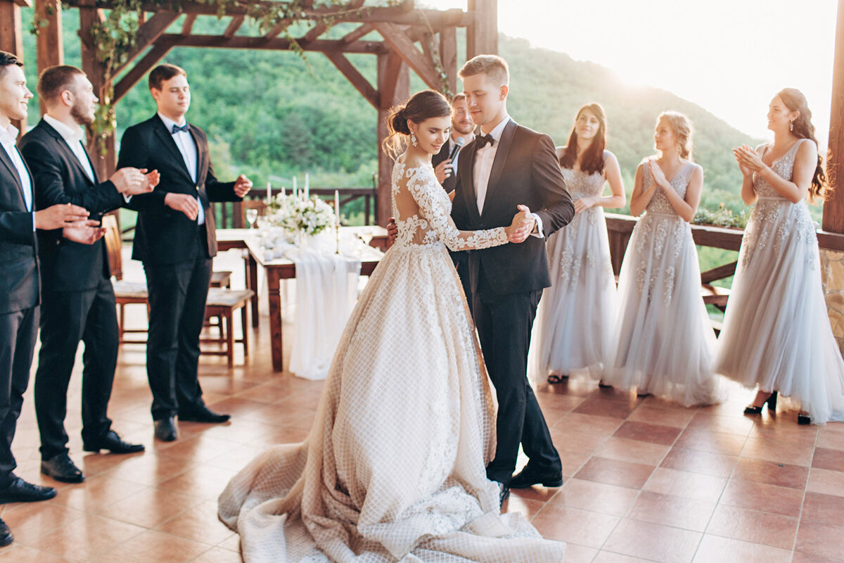 bride and groom dancing their first dance near the wedding party