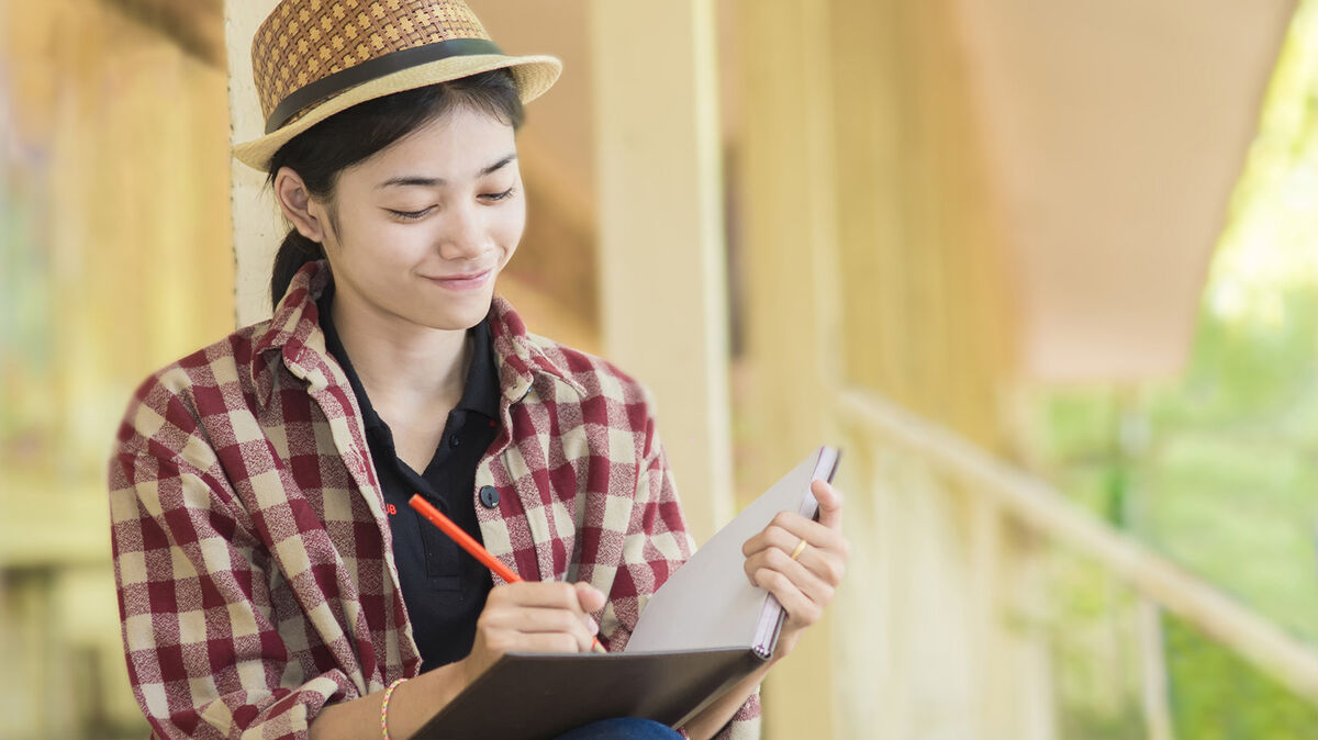 woman doing creative writing in book